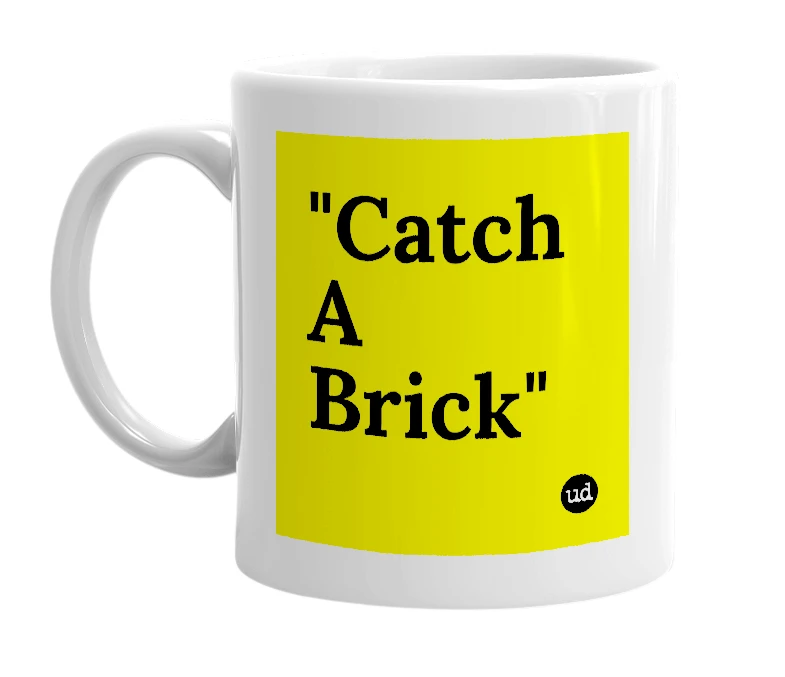 White mug with '"Catch A Brick"' in bold black letters