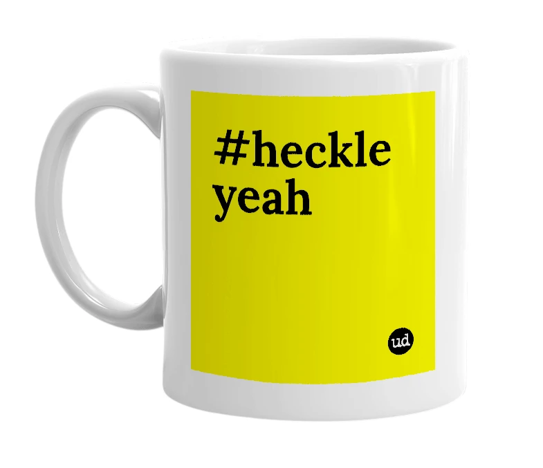 White mug with '#heckle yeah' in bold black letters