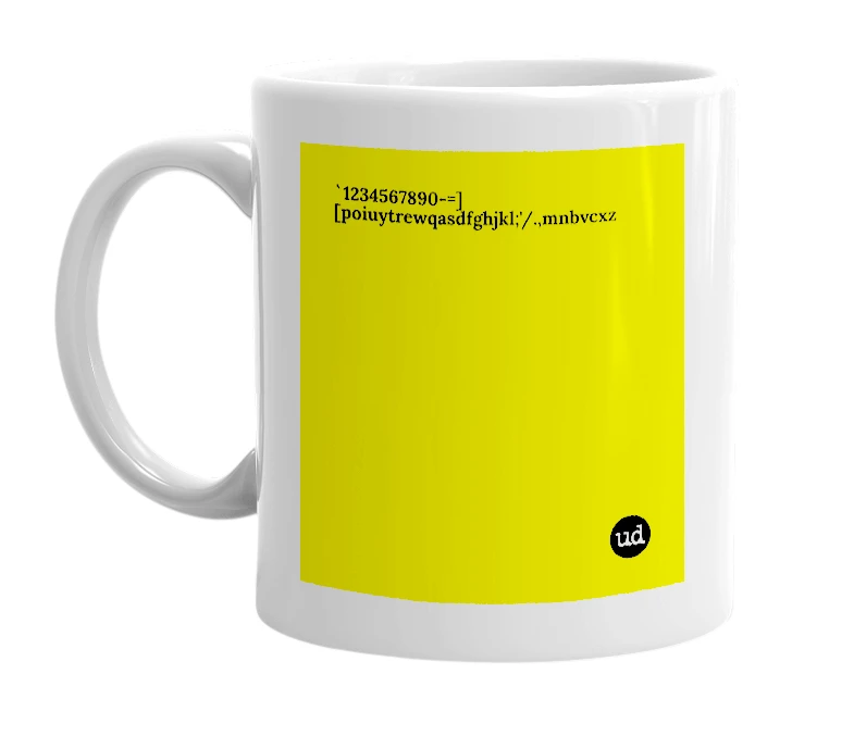 White mug with '`1234567890-=][poiuytrewqasdfghjkl;'/.,mnbvcxz' in bold black letters