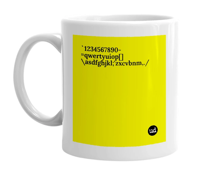 White mug with '`1234567890-=qwertyuiop[]\asdfghjkl;'zxcvbnm,./' in bold black letters