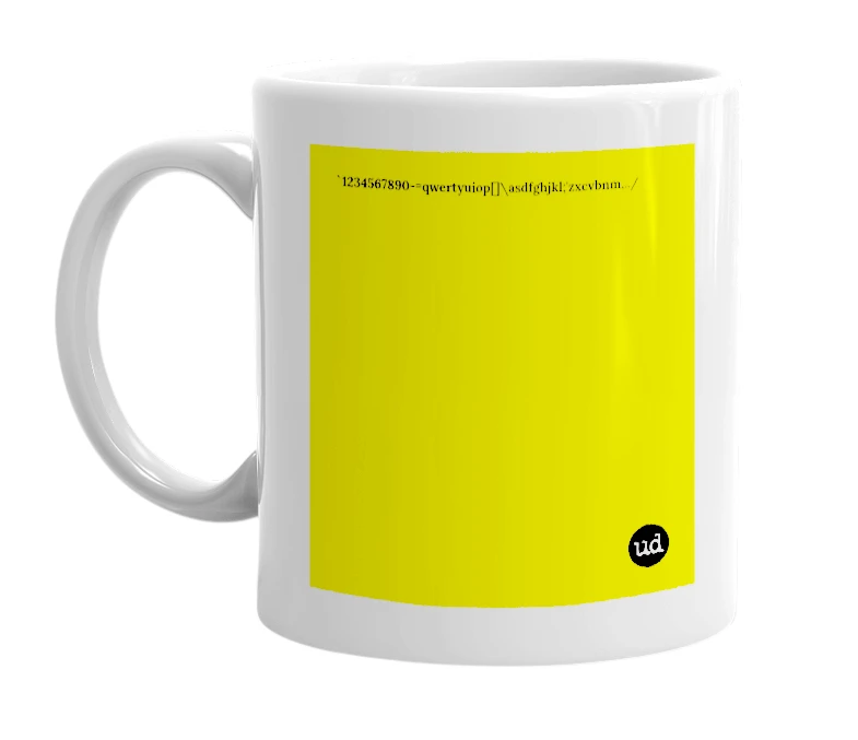 White mug with '`1234567890-=qwertyuiop[]\asdfghjkl;'zxcvbnm,../' in bold black letters