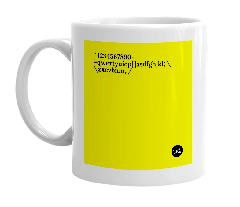 White mug with '`1234567890-=qwertyuiop[]asdfghjkl;'\\zxcvbnm,./' in bold black letters
