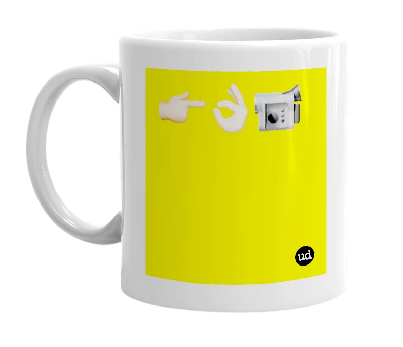 White mug with '👉🏻👌🏻📹' in bold black letters