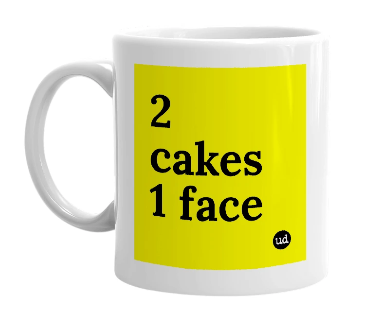 White mug with '2 cakes 1 face' in bold black letters