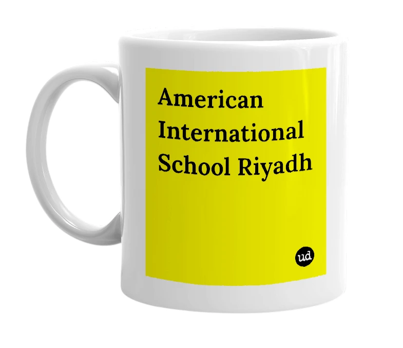 White mug with 'American International School Riyadh' in bold black letters