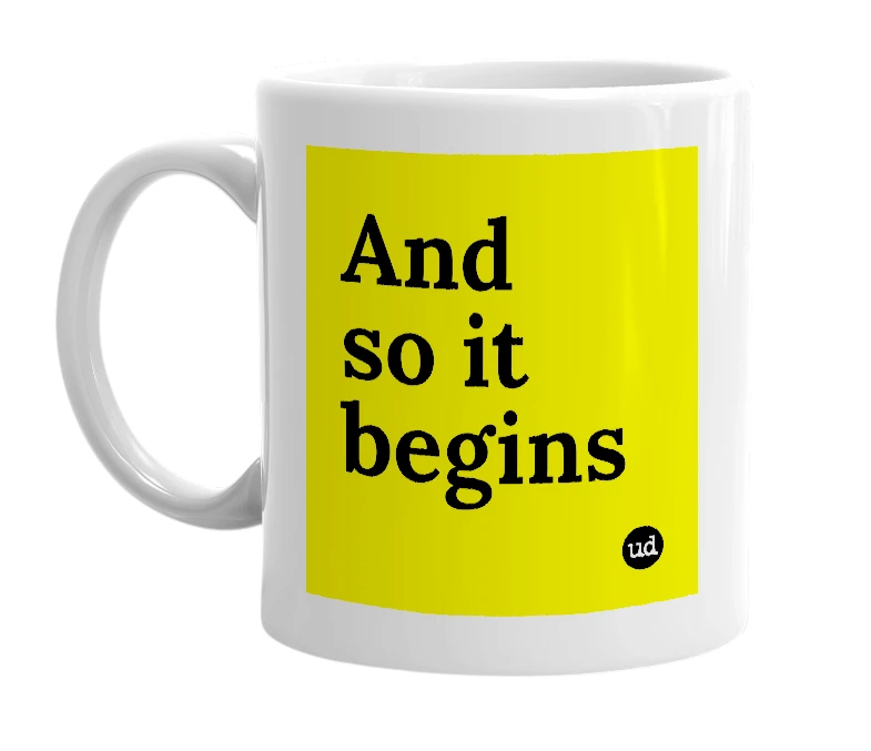 White mug with 'And so it begins' in bold black letters