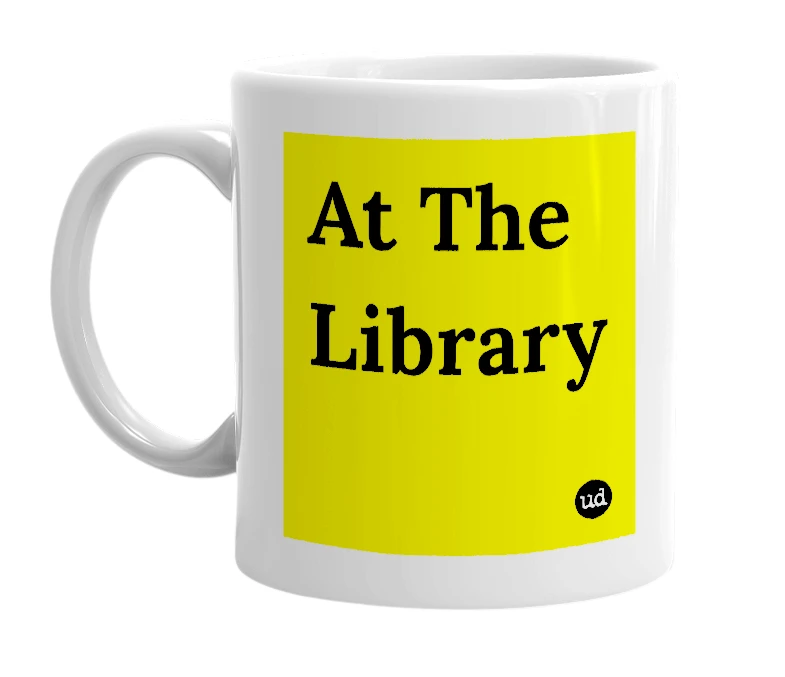 White mug with 'At The Library' in bold black letters