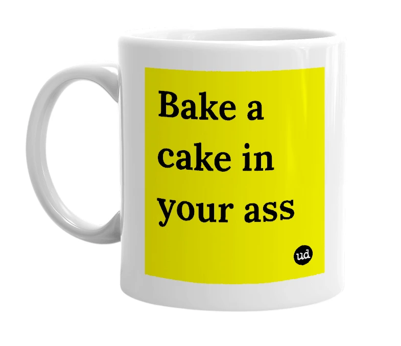 White mug with 'Bake a cake in your ass' in bold black letters