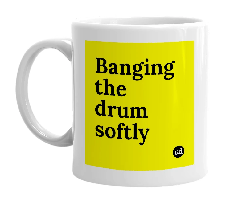 White mug with 'Banging the drum softly' in bold black letters
