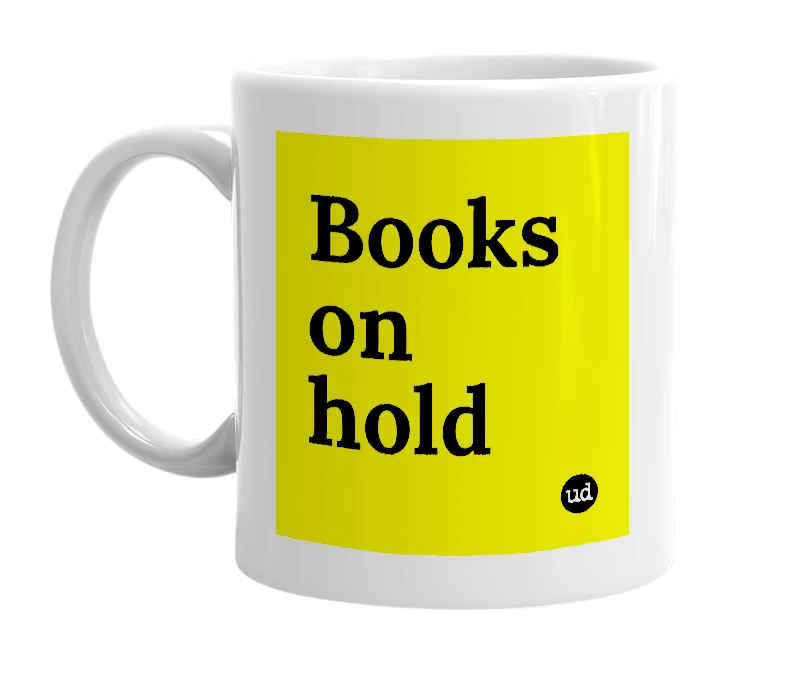 White mug with 'Books on hold' in bold black letters
