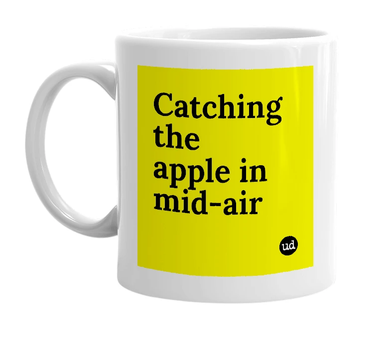 White mug with 'Catching the apple in mid-air' in bold black letters