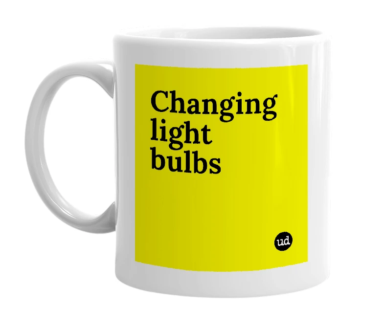 White mug with 'Changing light bulbs' in bold black letters