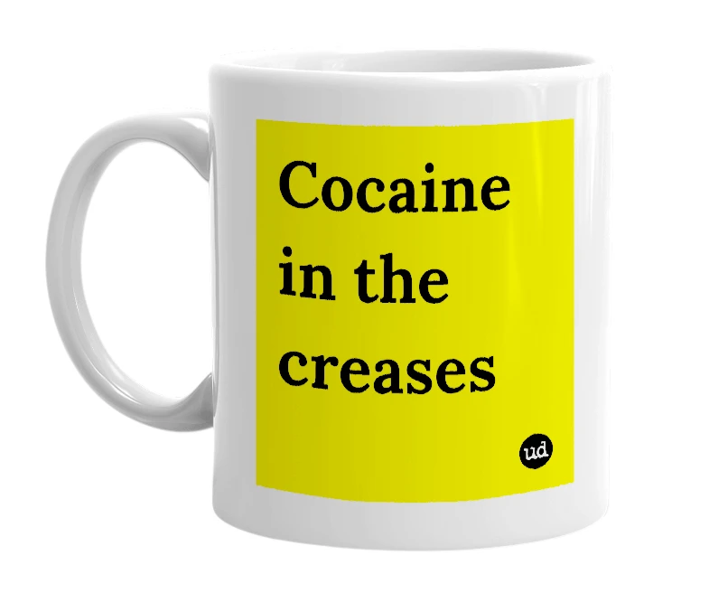 White mug with 'Cocaine in the creases' in bold black letters