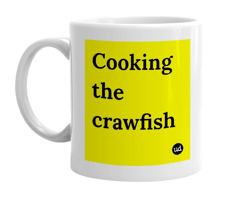 White mug with 'Cooking the crawfish' in bold black letters