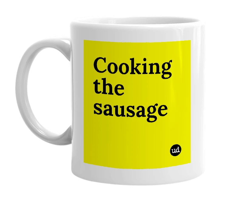 White mug with 'Cooking the sausage' in bold black letters