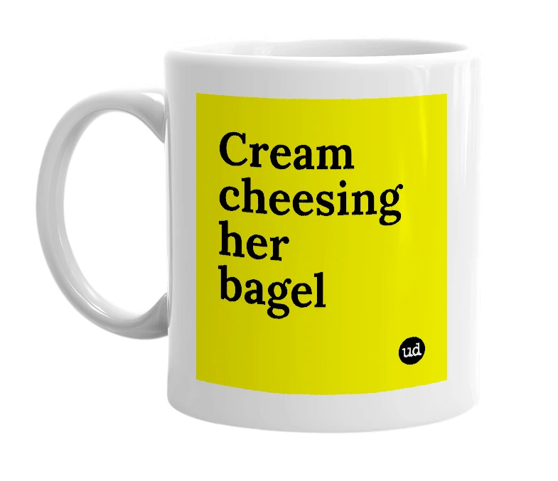 White mug with 'Cream cheesing her bagel' in bold black letters