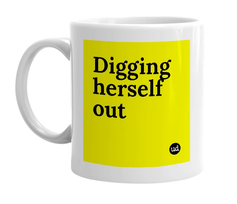 White mug with 'Digging herself out' in bold black letters