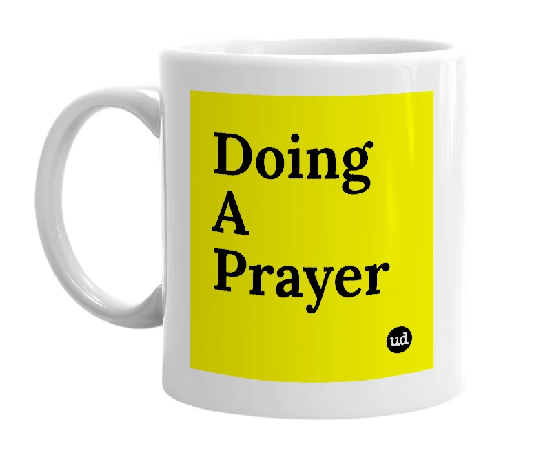 White mug with 'Doing A Prayer' in bold black letters