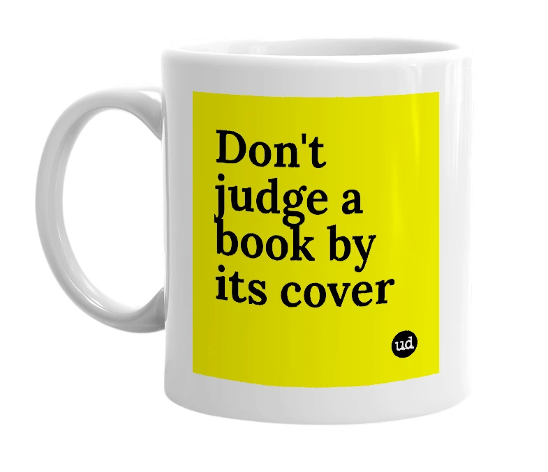 White mug with 'Don't judge a book by its cover' in bold black letters