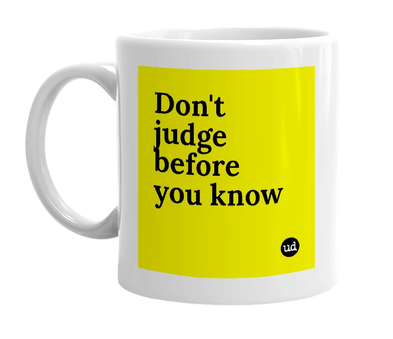 White mug with 'Don't judge before you know' in bold black letters