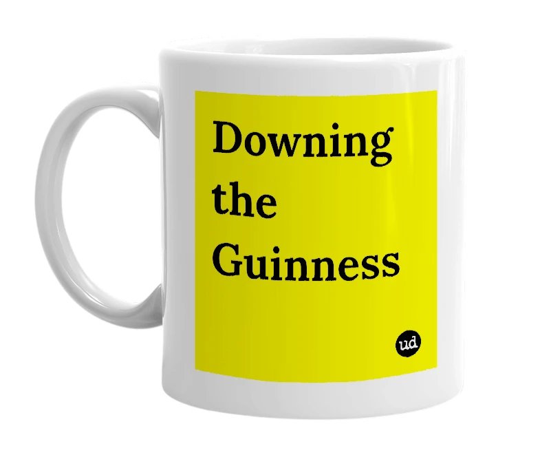 White mug with 'Downing the Guinness' in bold black letters