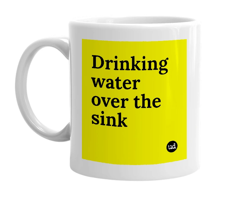 White mug with 'Drinking water over the sink' in bold black letters