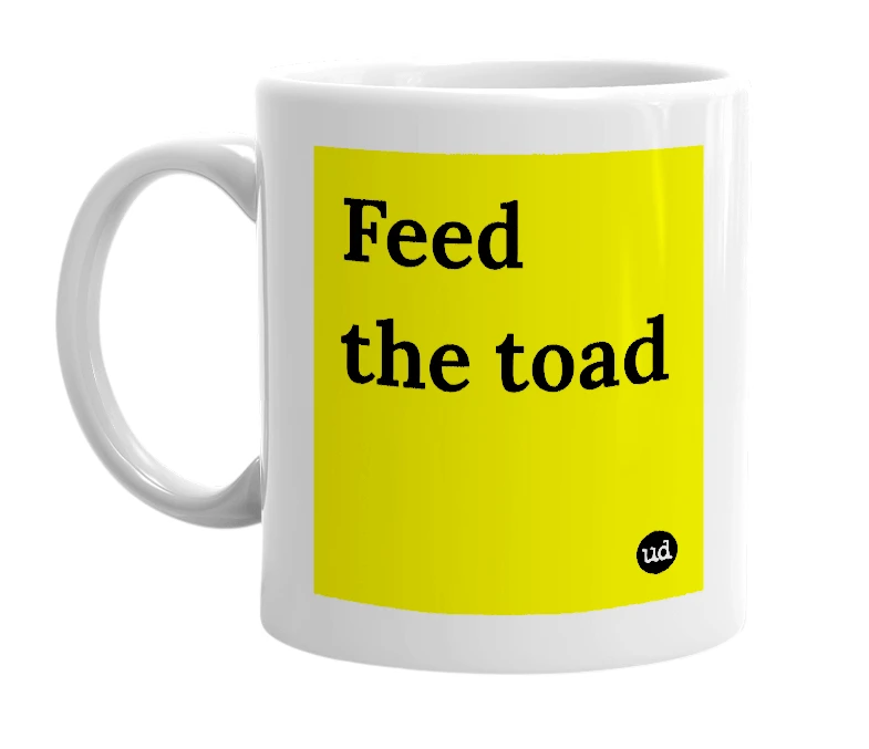White mug with 'Feed the toad' in bold black letters