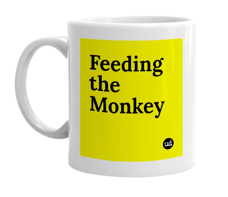 White mug with 'Feeding the Monkey' in bold black letters