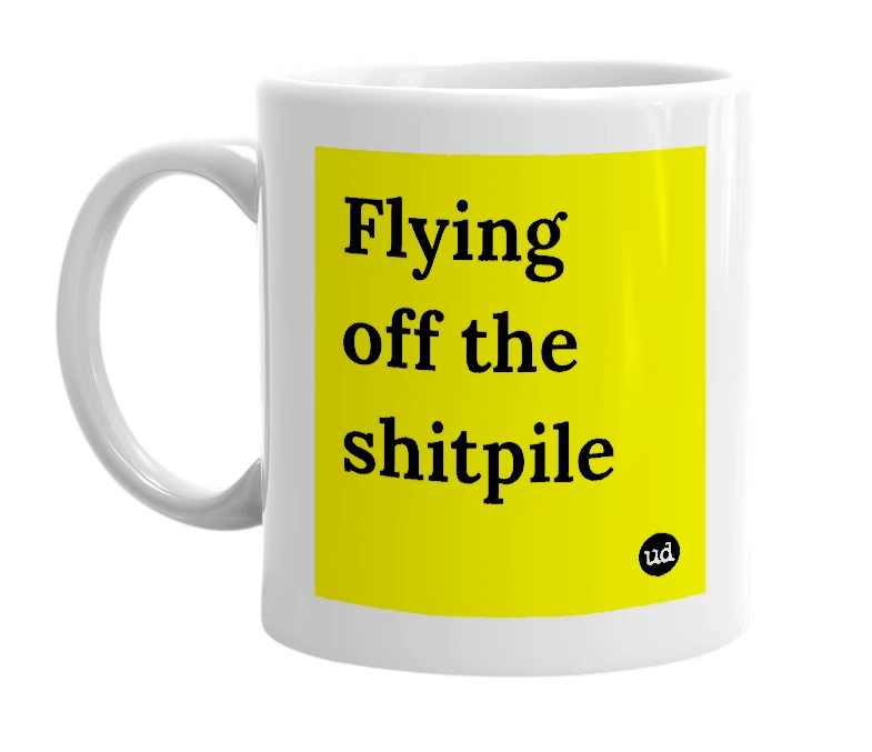 White mug with 'Flying off the shitpile' in bold black letters