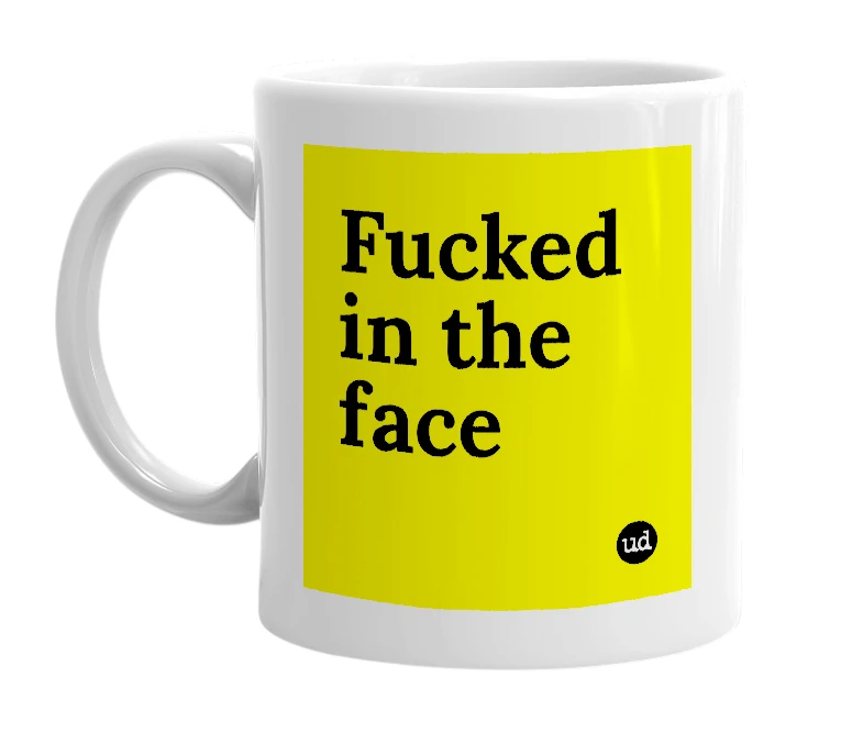 White mug with 'Fucked in the face' in bold black letters