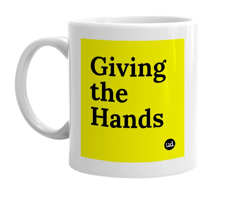 White mug with 'Giving the Hands' in bold black letters