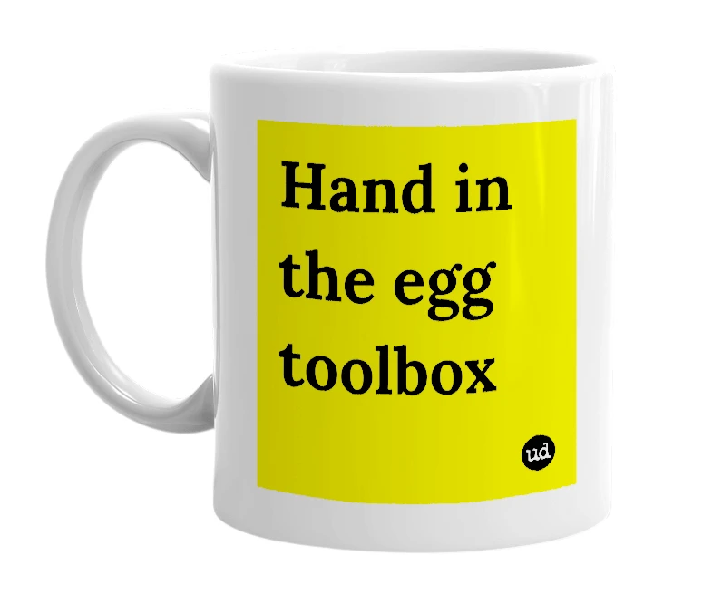 White mug with 'Hand in the egg toolbox' in bold black letters