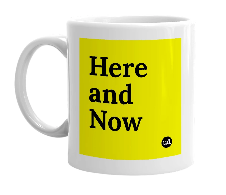 White mug with 'Here and Now' in bold black letters