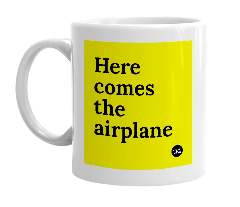 White mug with 'Here comes the airplane' in bold black letters