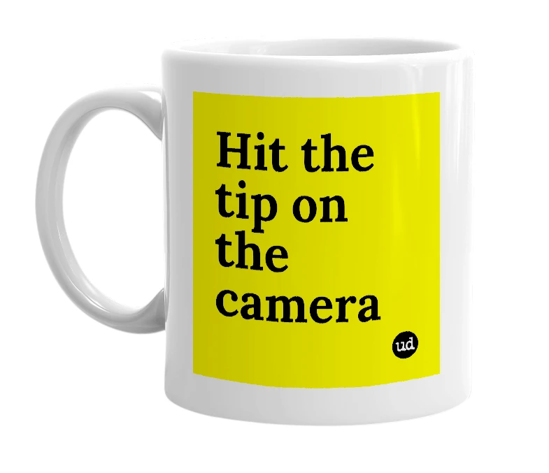 White mug with 'Hit the tip on the camera' in bold black letters