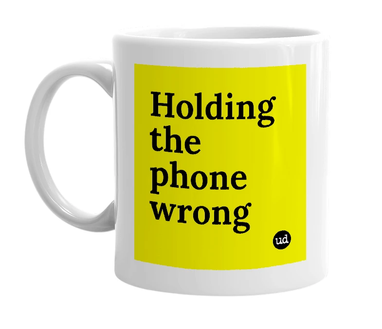 White mug with 'Holding the phone wrong' in bold black letters