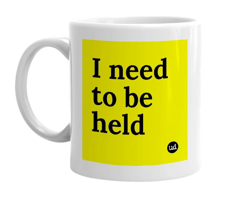 White mug with 'I need to be held' in bold black letters
