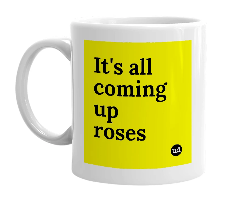 White mug with 'It's all coming up roses' in bold black letters