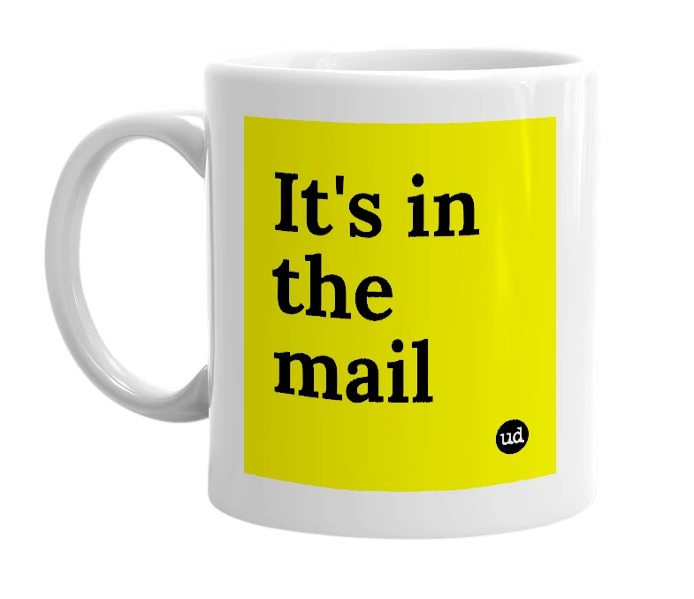 White mug with 'It's in the mail' in bold black letters