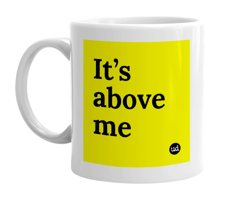 White mug with 'It’s above me' in bold black letters