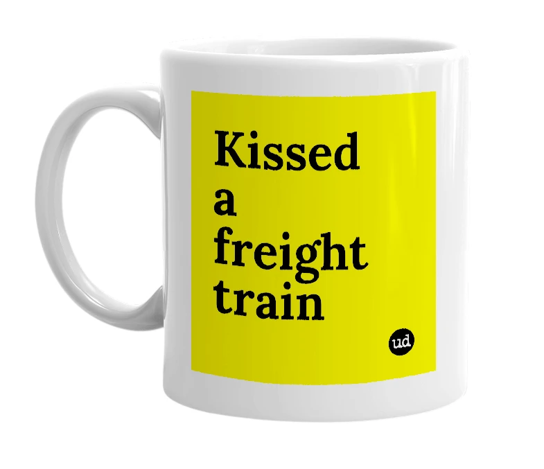 White mug with 'Kissed a freight train' in bold black letters