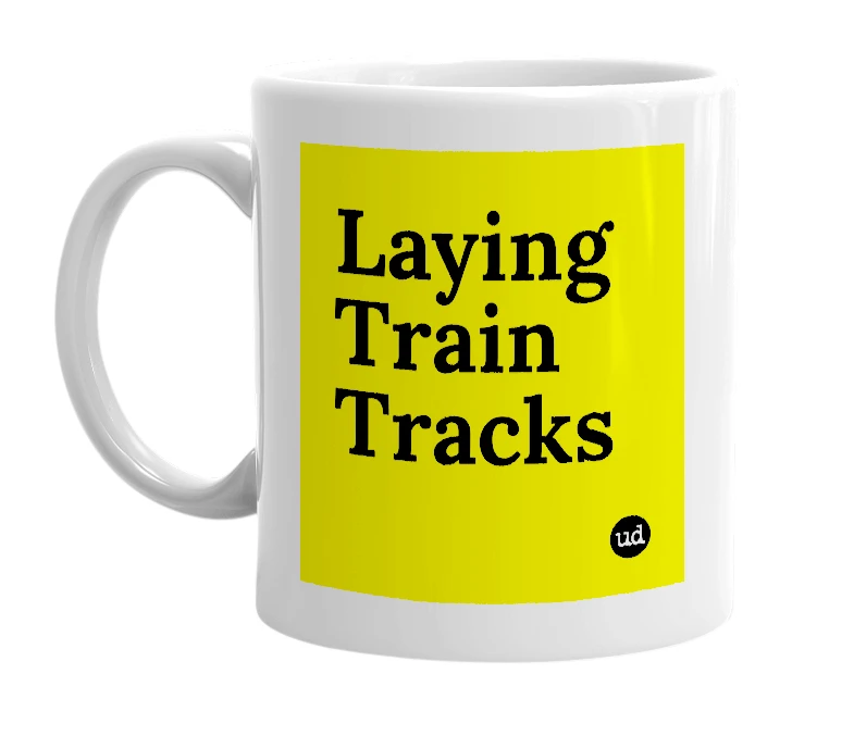 White mug with 'Laying Train Tracks' in bold black letters