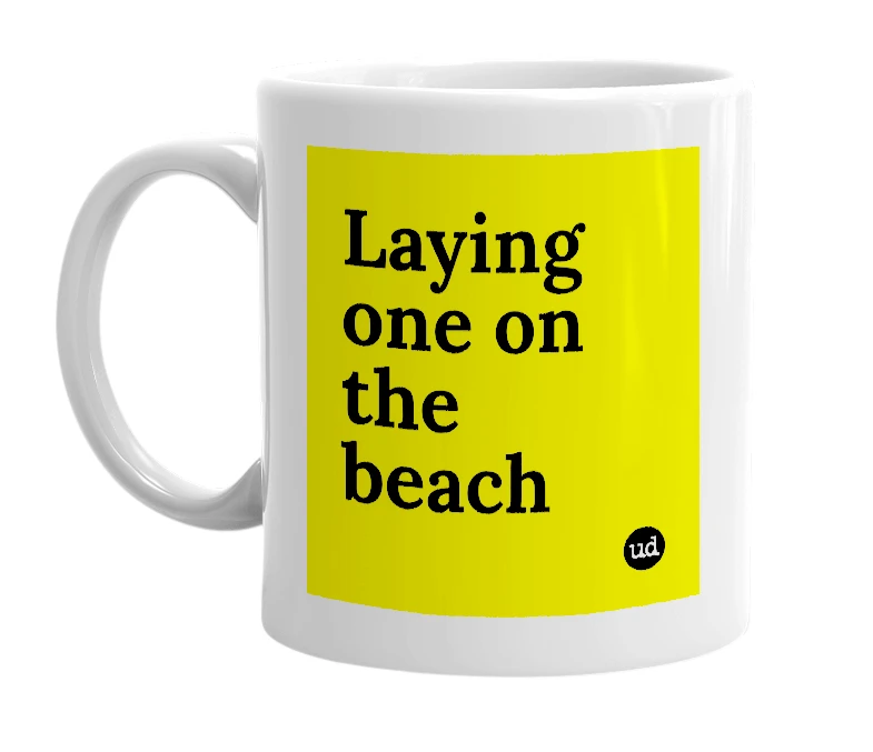 White mug with 'Laying one on the beach' in bold black letters