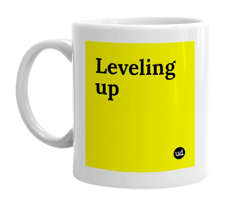 White mug with 'Leveling up' in bold black letters