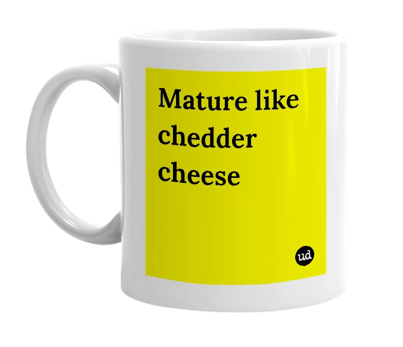 White mug with 'Mature like chedder cheese' in bold black letters