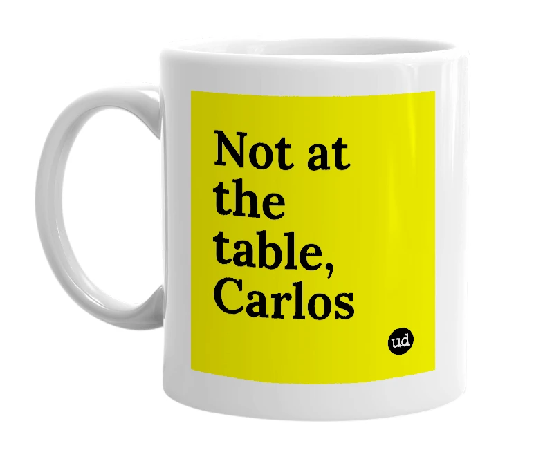 White mug with 'Not at the table, Carlos' in bold black letters