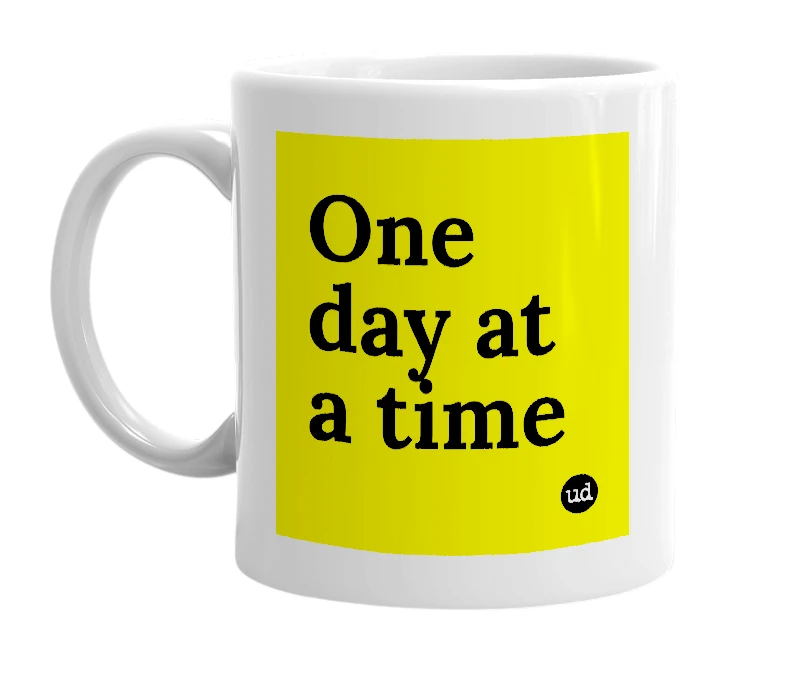 White mug with 'One day at a time' in bold black letters