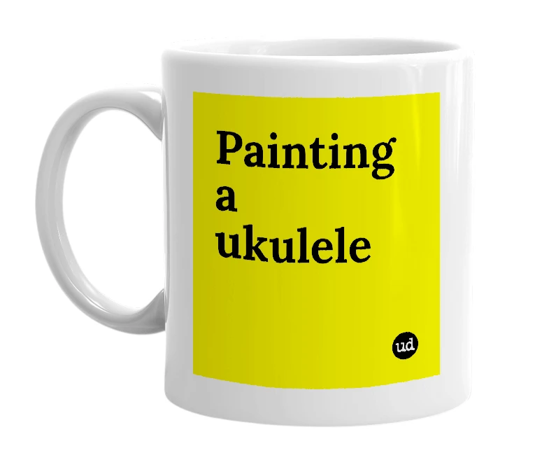 White mug with 'Painting a ukulele' in bold black letters