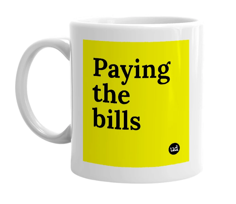 White mug with 'Paying the bills' in bold black letters