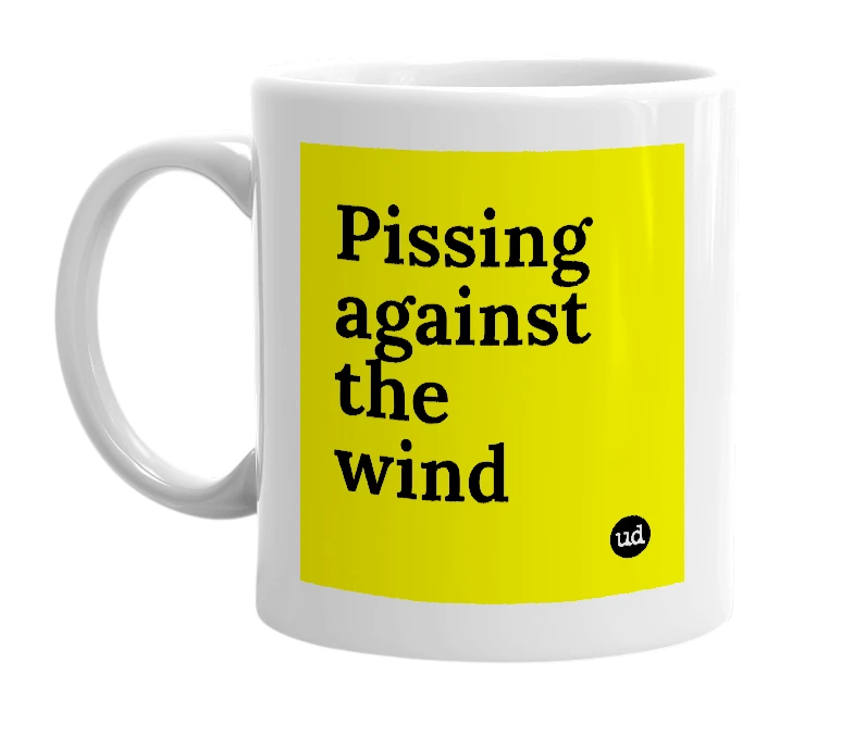 White mug with 'Pissing against the wind' in bold black letters